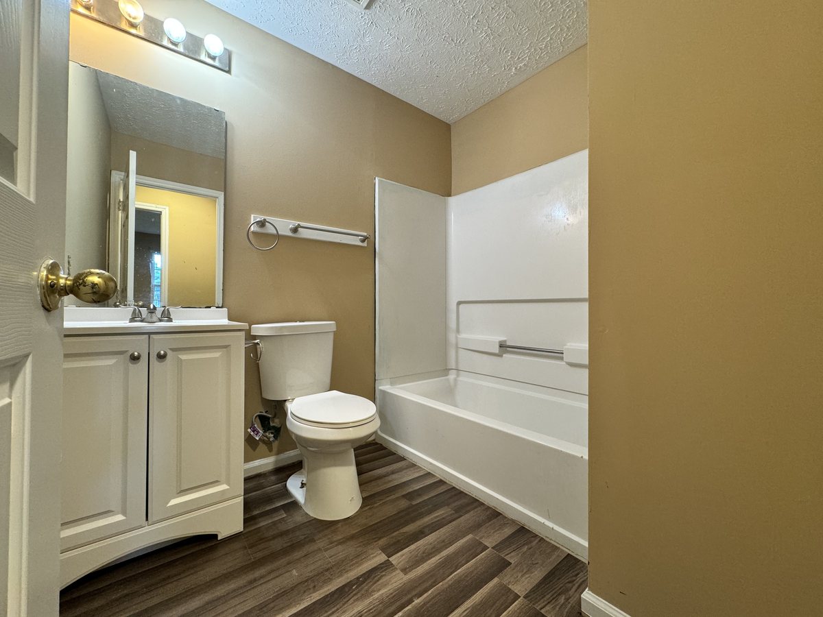 The finished primary bathroom with new vanity and tub surround