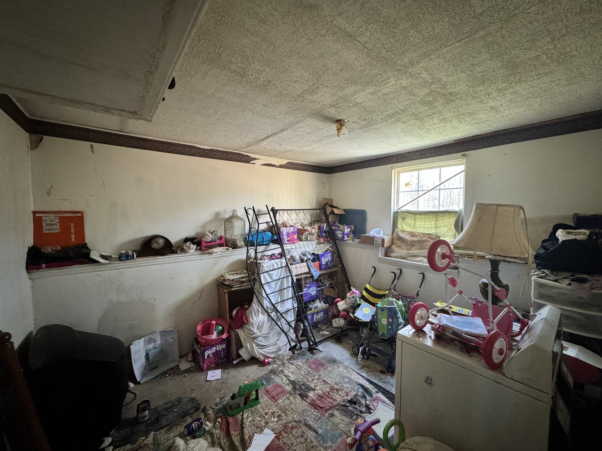 Wendell back bedroom with ceiling damage and belongings left behind