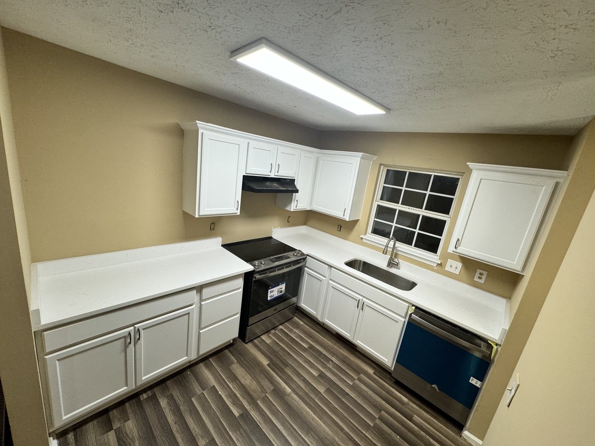 The finished Wendell kitchen with white cabinets and new flooring